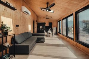 ein Wohnzimmer mit einem Sofa und einigen Fenstern in der Unterkunft Kabins - Homestay Near Pawna Lake, Lonavala in Lonavla