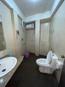 uma casa de banho com um WC branco e um lavatório. em Backpackers Den (TRC) em Gangtok