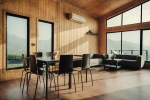 - une salle à manger avec une table, des chaises et un canapé dans l'établissement Kabins - Homestay Near Pawna Lake, Lonavala, à Lonavala