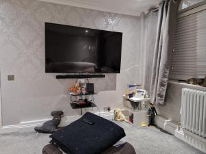 a living room with a flat screen tv on the wall at Luxury on a Budget in Chelmsford