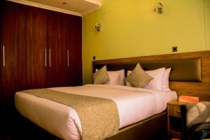 埃尔多雷特TJ's Boutique Hotel的卧室里有一张铺着白色床单的大床 更多36张照片