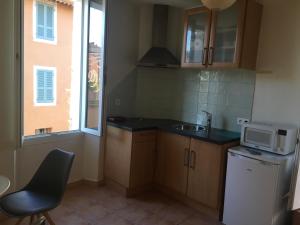 a small kitchen with a sink and a microwave at Coeur de village in Bormes-les-Mimosas
