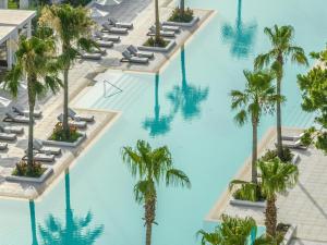 an overhead view of a pool with palm trees at Grecotel Lux Me Dama Dama in Faliraki