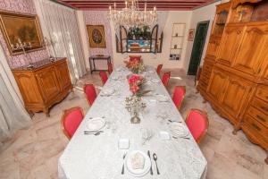 a dining room with a long table and red chairs at Riad Raja in La Soukra