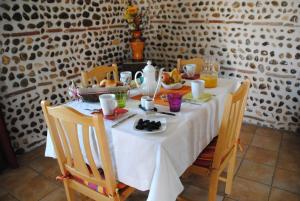 una mesa con un mantel blanco y comida en ella en Gîte Matran, en Cauna