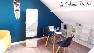 Habitación con mesa, sillas y espejo. en La Cabane De Pol en Dunkerque