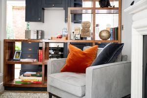 a living room with a chair with an orange pillow at The Aldwark in York