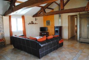 a living room with a black couch and a tv at Gîte Matran in Cauna