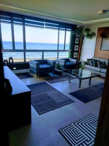 uma sala de estar com sofás e vista para o oceano em Vista Mar Santos canal 2 em Santos