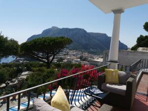 uma varanda com vista para a cidade e para as montanhas em MARVELOUS SEA VIEW VILLA em Capri