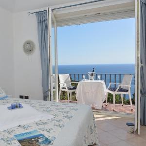 una stanza con tavolo, sedie e l'oceano di MARVELOUS SEA VIEW VILLA a Capri