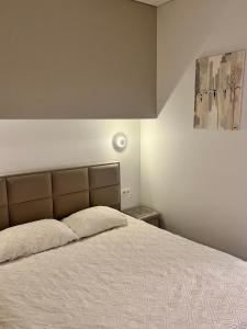 1 dormitorio con 1 cama con colcha blanca en Cozy Apartment with Garden & Terrace in Kaunas, en Kaunas