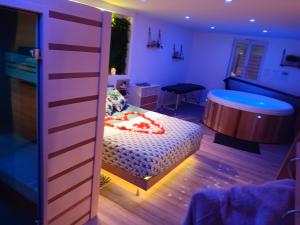 a bedroom with a bed and a table in a room at Gîte et SPA Au Secret Du Bonheur in Pouilly-sur-Serre