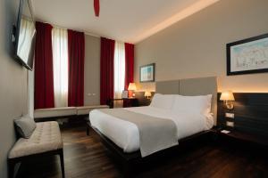 um quarto de hotel com uma cama e uma cadeira em 10 KEYS MILANO em Milão