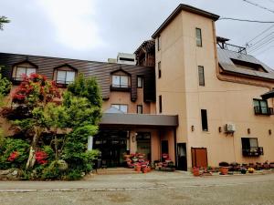 a large building with flowers in front of it at Hakuba Hotel Hana-no-Sato in Hakuba
