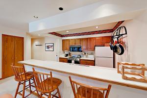 una cucina con armadi in legno e piano di lavoro bianco di Townsend Place B206 a Beaver Creek
