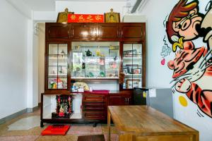 Taladnoi Paint House في بانكوك: غرفة مع خزانة خشبية وطاولة