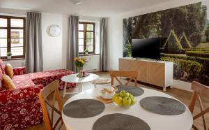 ein Wohnzimmer mit einem Tisch und einem TV in der Unterkunft Apartmány Myslivna in Ostrov