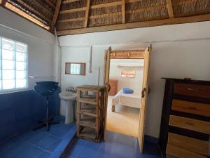 a small room with a bunk bed and a toilet at Chez Peter Pan Anakao in Anakao