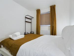 um quarto com uma cama com lençóis brancos e uma janela em Cosy and luxurious house for 10 guests in Darwen em Darwen