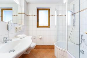 uma casa de banho com uma banheira, um lavatório e um WC. em Hotel Schlehdorn em Feldberg