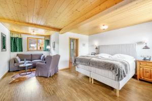 ein Schlafzimmer mit einem Bett und einem Sofa in der Unterkunft Hotel Schlehdorn in Feldberg