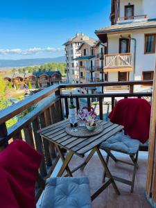 a table on a balcony with a bottle of wine at Kate's apartment in Pirin in Razlog