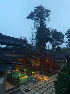 a house with a swimming pool and a patio at SylVan Resort in Wayanad
