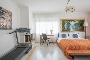 een slaapkamer met een bed en een loopband. bij Varkiza Riviera in Varkiza
