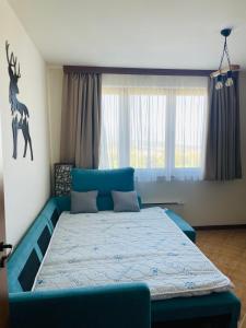 a bedroom with a blue bed with a deer head on the wall at Kate's apartment in Pirin in Razlog