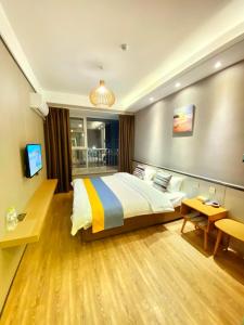 Qingdao Shuiyunjian Apartment في تشينغداو: غرفة نوم بسرير وتلفزيون في غرفة