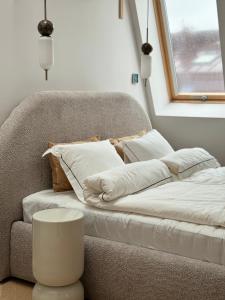 a couch with pillows and a table in front of a window at URBAN Penthouse FREE parking i rowery in Poznań
