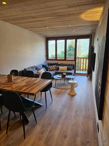 a living room with a table and a couch at Praloup 1600 Appartement T4 rénové in Uvernet-Fours +10 photos