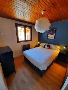 a bedroom with a large white bed and a wooden ceiling at Praloup 1600 Appartement T4 rénové in Uvernet-Fours