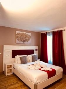 um quarto com uma cama grande e cortinas vermelhas em Pavillon Opéra Lafayette em Paris