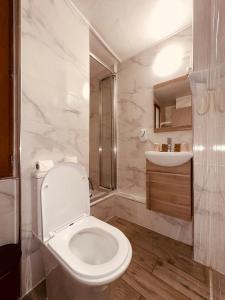 a white bathroom with a toilet and a sink at Pavillon Opéra Lafayette in Paris +78 photos
