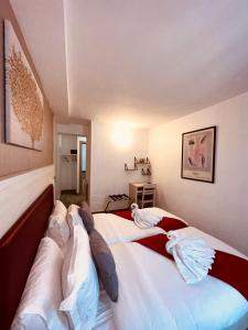 a bedroom with two beds with pillows on them at Pavillon Opéra Lafayette in Paris