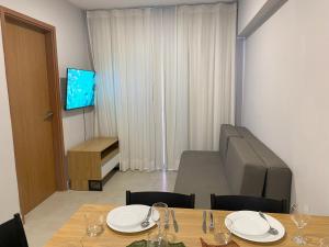 a dining room with a table and a television at Vila Atlântida Beach in Luis Correia