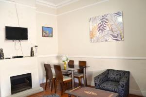 Cape Town的住宿－149 ROCHESTER ROAD. OBSERVATORY，客厅配有桌子和壁炉
