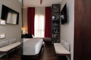 um quarto de hotel com uma cama e um sofá em 10 KEYS MILANO em Milão