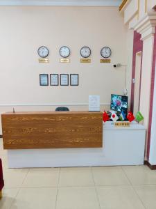 a reception desk with clocks on the wall at Hotel Zavq in Andijan