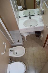 La petite salle de bains est pourvue d'un lavabo et de toilettes. dans l'établissement Hotel Mary, à La Spezia