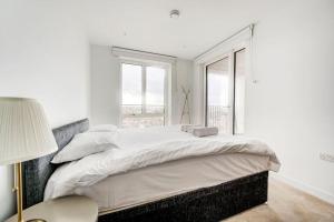 um quarto branco com uma cama grande e uma janela em GuestReady - Chic Urban Haven in Walworth em Londres