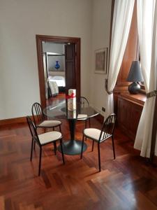 jadalnia ze szklanym stołem i 2 krzesłami w obiekcie Princess house Roma w Rzymie