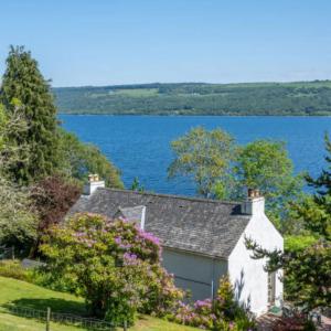 a house with a view of a lake at Loch Ness Cottages in Brackla