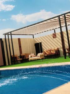 a patio with chairs and a swimming pool at شاليهات توليب in Sabt Alalayah
