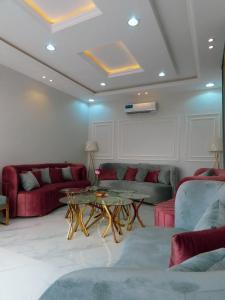 a living room with two couches and a table at شاليهات توليب in Sabt Alalayah