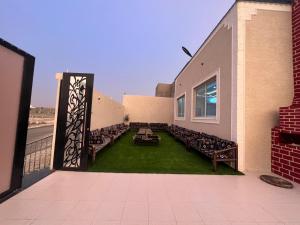 a patio with chairs and tables on the side of a building at شاليهات توليب in Sabt Alalayah