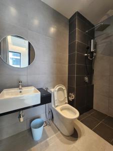 Executive Urban Suites - George Town @ Penang في Jelutong: حمام مع مرحاض ومغسلة ومرآة