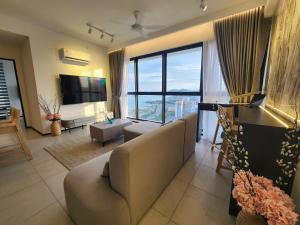 Executive Urban Suites - George Town @ Penang في Jelutong: غرفة معيشة مع أريكة ونافذة كبيرة